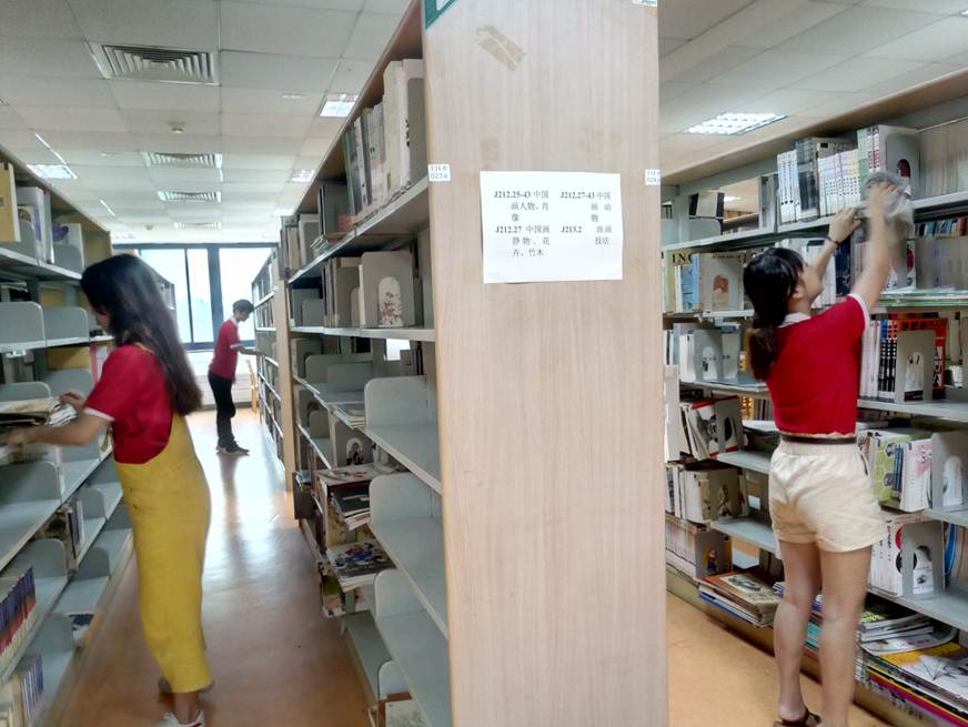 说明: D:\2019年新闻\5月29日 商学院学生党支部开展“清心阅书，清净悦物”志愿服务活动\认真清洁书架.jpg